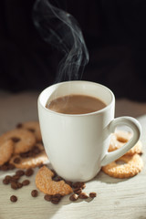 white cup of coffee with milk and cookies and coffee beans