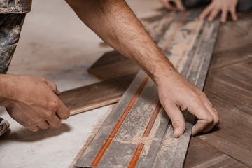 carpenter cutting wood plank with saw