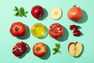 Flat lay with apple, honey and pomegranate on mint background