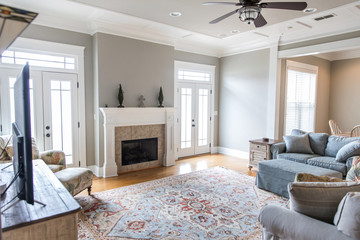 a bright and airy neutral beige living room den in a new construction house with a white and tiled...
