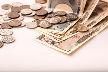 Japanese coins and banknotes and passport on white table