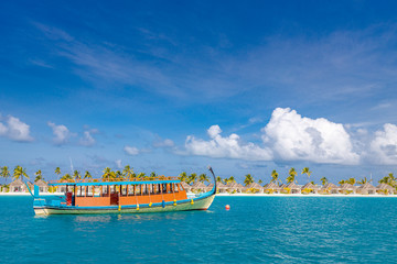 Fototapeta na wymiar Exotic Maldives beach landscape. Maldives traditional boat Dhoni and perfect blue sea with lagoon. Luxury tropical paradise concept. Amazing landscape 