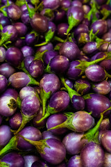 Street shop counter with vegetables. A pile of eggplant in a wooden box