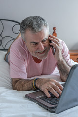 Mature man with beard working in the bed