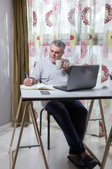 Mature man with a beard working at home