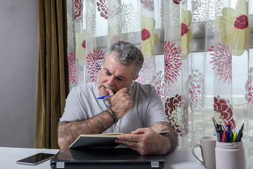Fototapeta premium Mature man with a beard working at home