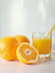 Glass of fresh orange juice on white table