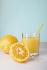 Glass of fresh orange juice on white table