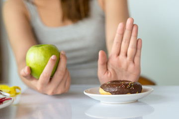 Dieting or good health concept. Young woman rejecting Junk food or unhealthy food such as donut or...