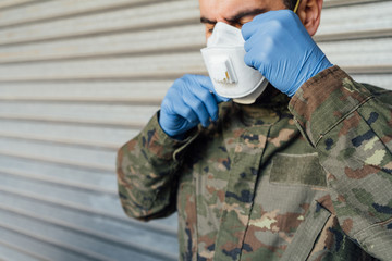 Military portrait with gloves putting on a mask. Pandemic crisis, Spanish soldier.