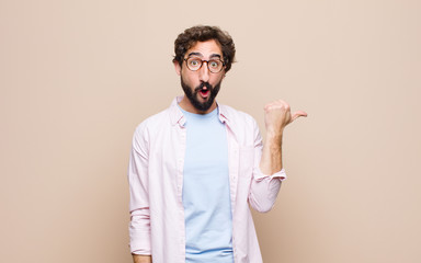 young cool bearded man expressing a concept against flat wall