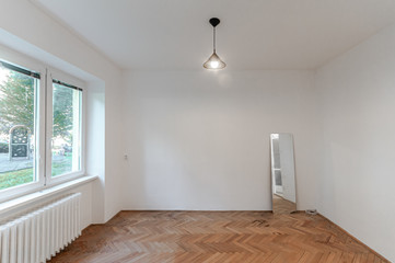 Empty room with white walls, wooden floor and window 
