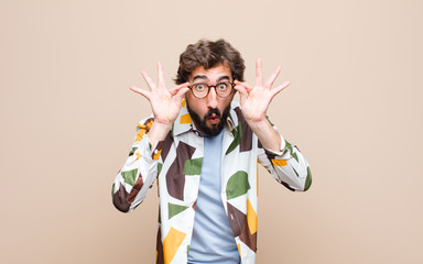 young cool bearded man expressing a concept against flat wall