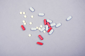Colored medicine pills on light grey surface.