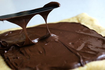 liquid chocolate flows from the knife to the surface
