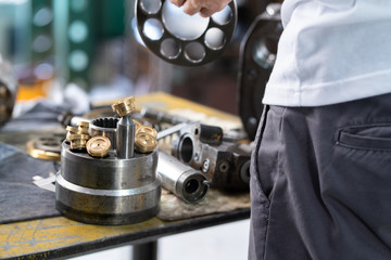 Piston and piston block of the hydraulic pump on working table, inspection and repair maintenance...