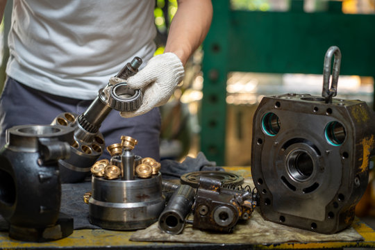 Professional Mechanic Man Holding Bearing Of The Hydraulic Piston Pump To Inspection And Repair Maintenance Heavy Machinery