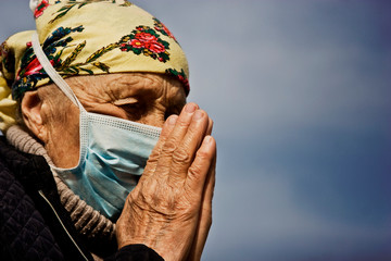 An elderly woman will forgive God's help due to the infection of many people with the coronavirus. The prayer of the old grandmother during the outbreak of coronavirus infection and the pandemic of th