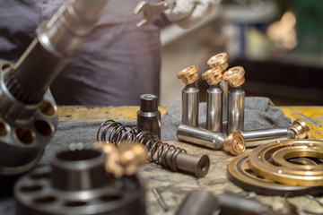 Piston of the hydraulic piston pump on working table, inspection and repair maintenance heavy...