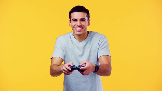 excited man with joystick isolated on yellow