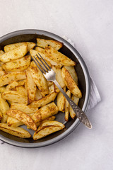 Roasted or Baked Potatoes With Spice in Black Bowl on Light Gray Background Tasty Homemade Dish Dinner Grilled Potatoes Top View
