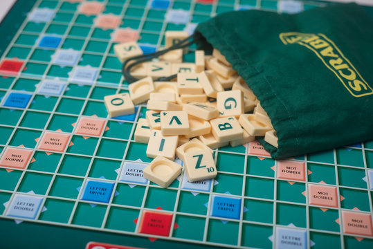Mulhouse - France - 1 April 2020 - Closeup of plastic letters of Scrabble game fallen from bag on boardgame