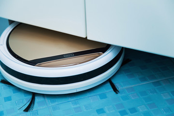 smart vacuum cleaner cleans under the cabinets, Robot vacuum cleaner performs automatic cleaning of...