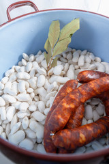 Beans with sausage and laurel in a pot.