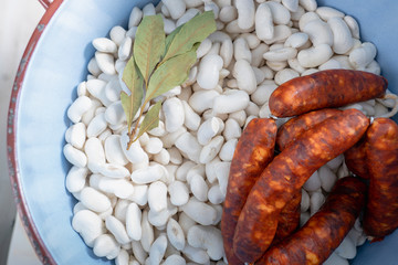 Beans with sausage and laurel in a pot.