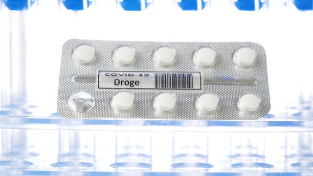 27942_A_tablet_of_white_medicine_pills_with_drug_Covid-19_Droge_written_in_German_for_coronavirus.mov
