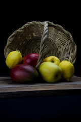 mangoes and yellow apples with a basket of natural cane