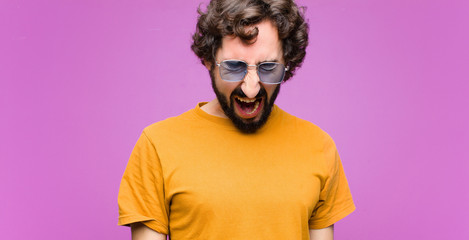 young crazy cool man shouting aggressively, looking very angry, frustrated, outraged or annoyed,...