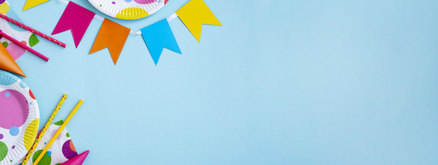 Birthday party decoration on a blue background,streamers,birthday caps,drinking straws and plates....