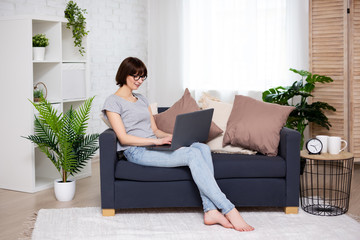 portrait of young woman using laptop in living room