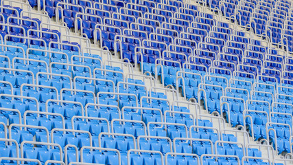 Obraz premium Empty blue and dark-blue seats in the stadium before the match