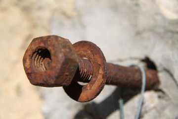 Sealed rusty iron nut bolt and screw in a wall