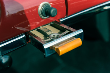 Vintage ash tray pulled out from dashboard of classic car.