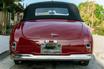 Classic 1951 Simca 8 Sport convertible car looks pretty from rear view with roof top up.