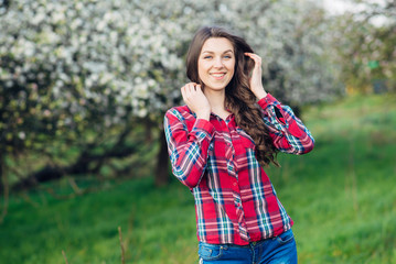 Young happy woman relax in blooming garden