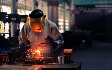 Industrial professional welder is welding metal part in the factory. skill and technician concept.