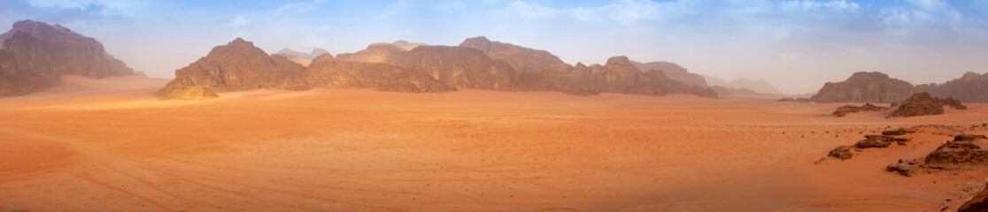 Fototapeta na wymiar Panorama wide angle of an empty Wadi Rum desert in spring, with some clouds in the air.
