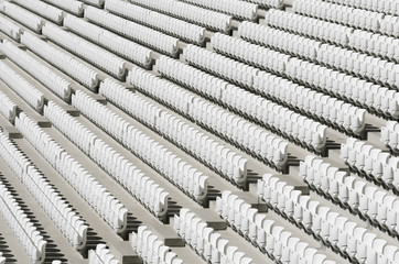 Rows of white empty plastic seats in a stadium