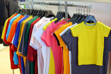 Summer T-shirts hang on a hanger in the store
