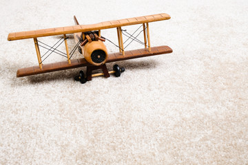 wooden airplane on the carpet © Alena Kryazheva