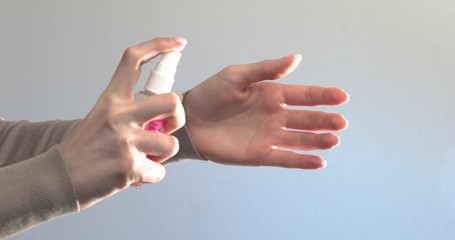 Girl sprayed on hands antiseptic for protection from bacterias and coronavirus. Right epidemic precautions. Clean hands tips