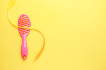 Hair brush and strand on color background