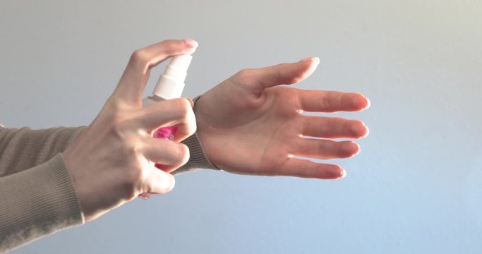 Girl sprayed on hands antiseptic for protection from bacterias and coronavirus. Right epidemic precautions. Clean hands tips