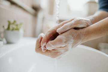 Closeup of a woman washing her hands in bathroom to prevent Covid-19 viral infection. Recommended...