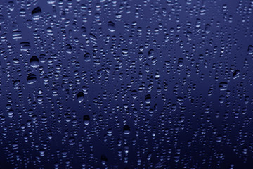 Water drops on blue background, top view