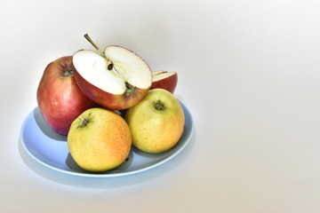 Red and yellow apple's close-up. Fruit on plate. Apples on a white background.